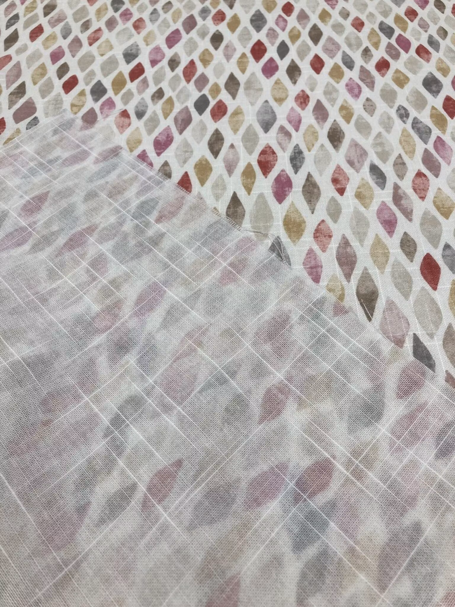 Närbild av Mosaik som visar den fina vävstrukturen och det småmönstrade rombmönstret i rosa, vinrött, gult, beige, brunt och naturvitt.
