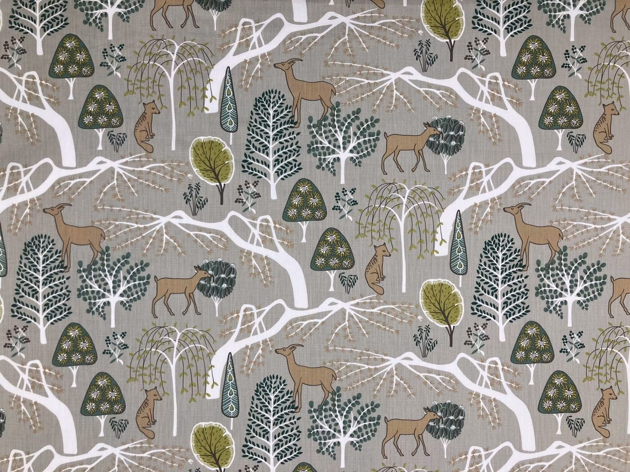 Sagoskog bomullstyg med skogsmotiv, träd och djur i naturnära färger, nordisk design