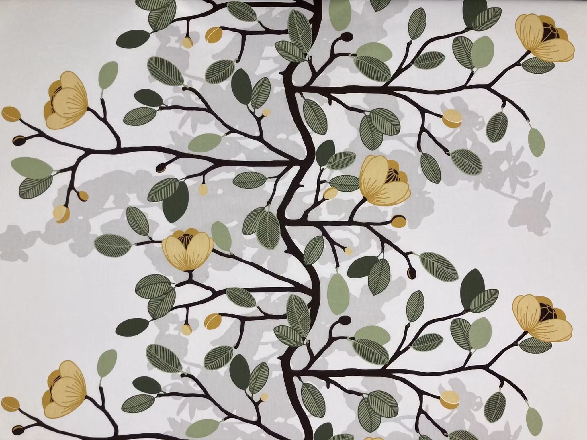 Ofelia gul bomullstyg med blommande kvistar och blad på ljus botten
