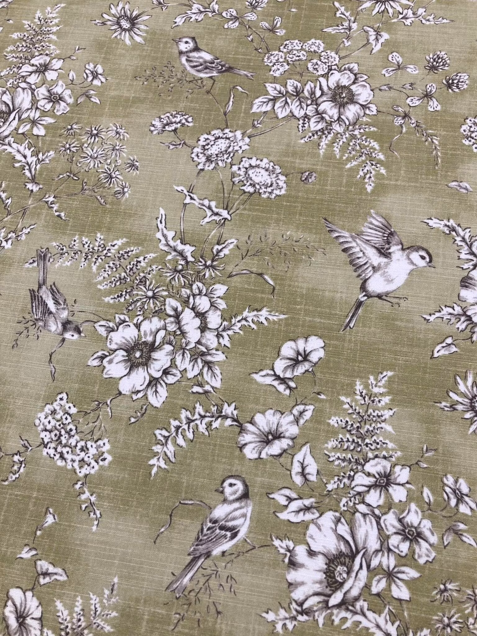 Närbild av Finch inredningstyg med fågelmotiv, blommor och blad i mjuka färger