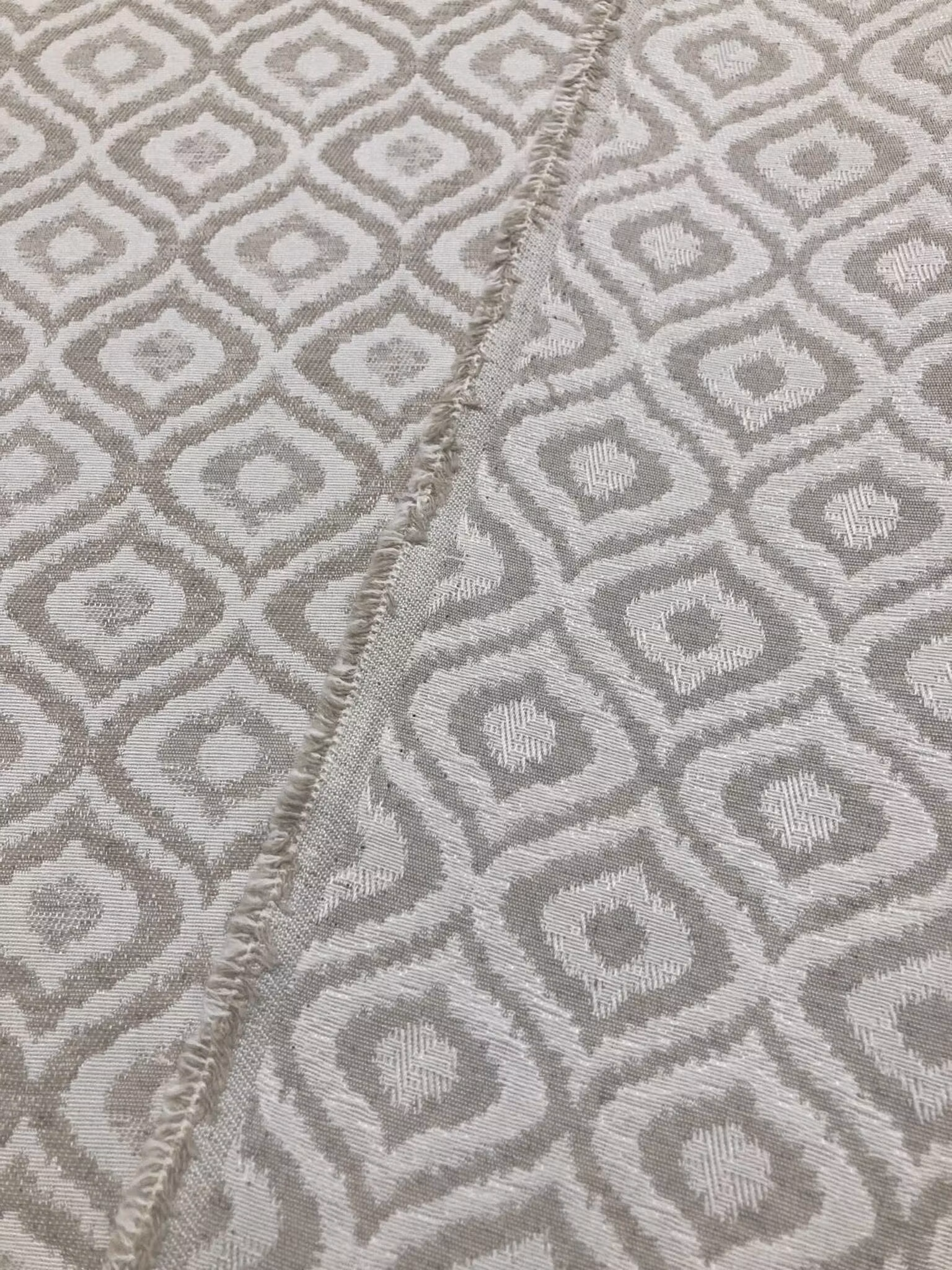 Närbild av Tapiceria Arcuri beige tyg med dekorativt geometriskt mönster