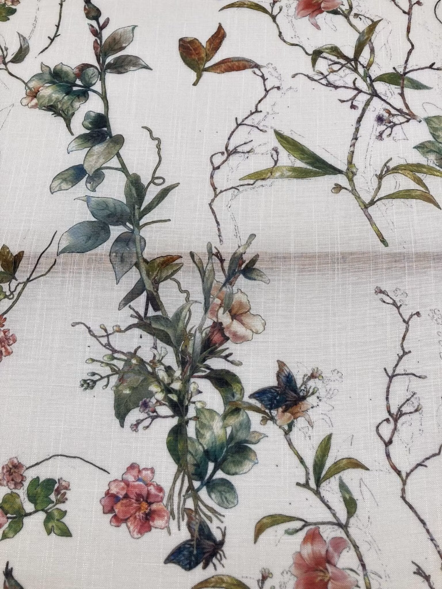 Närbild av Blomsterbris tyg med blommande grenar och mjuka färgtoner
