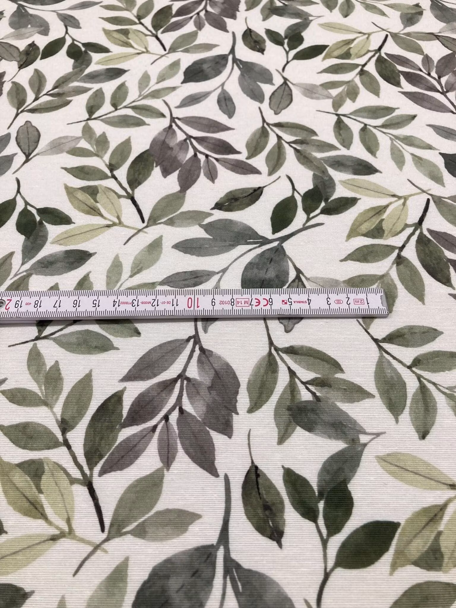 Närbild av Löv grön grå inredningstyg med gröna blad och växtmönster