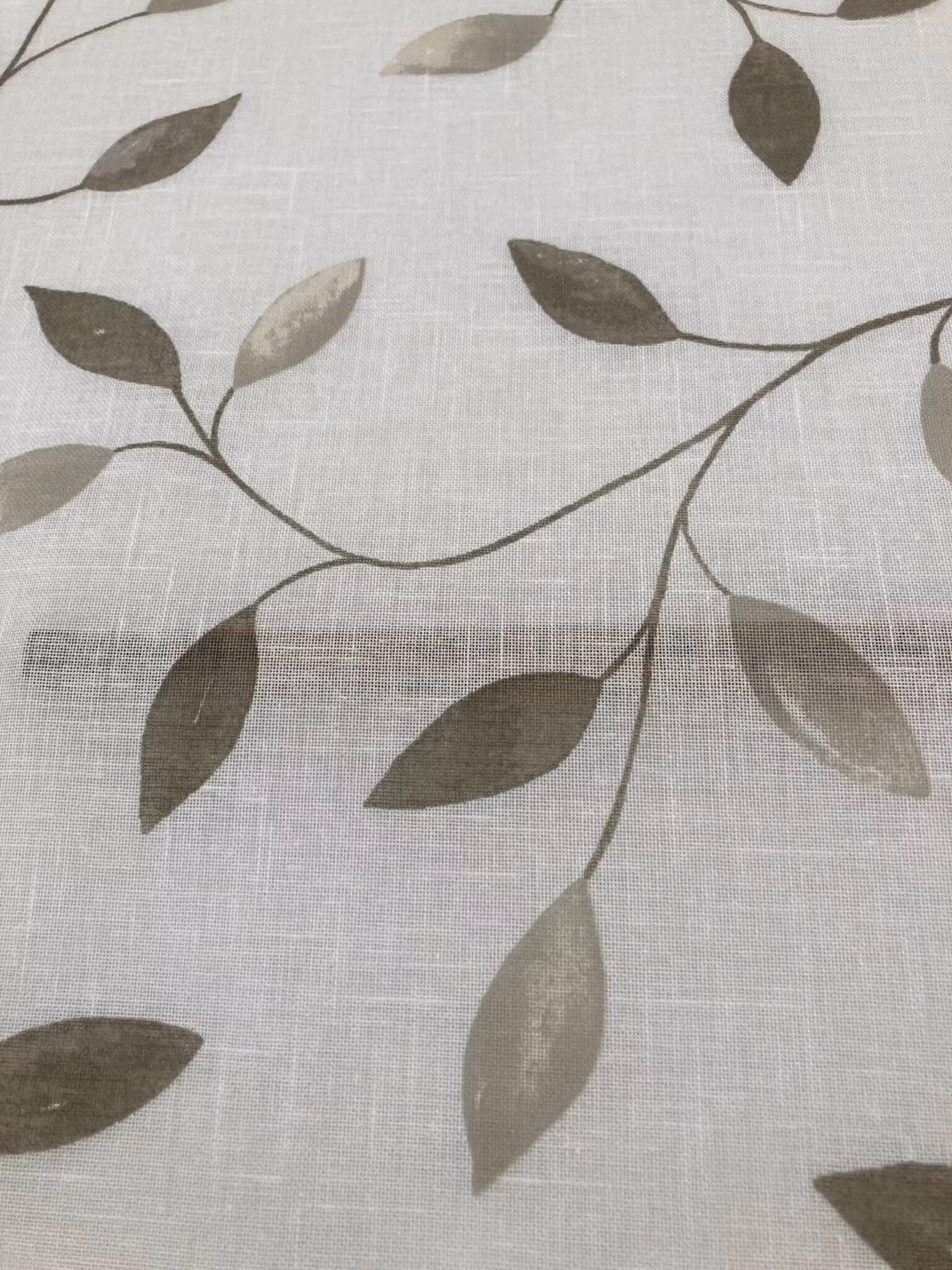 Närbild av Abedul beige gardintyg med blad i sand och gråbeige nyanser