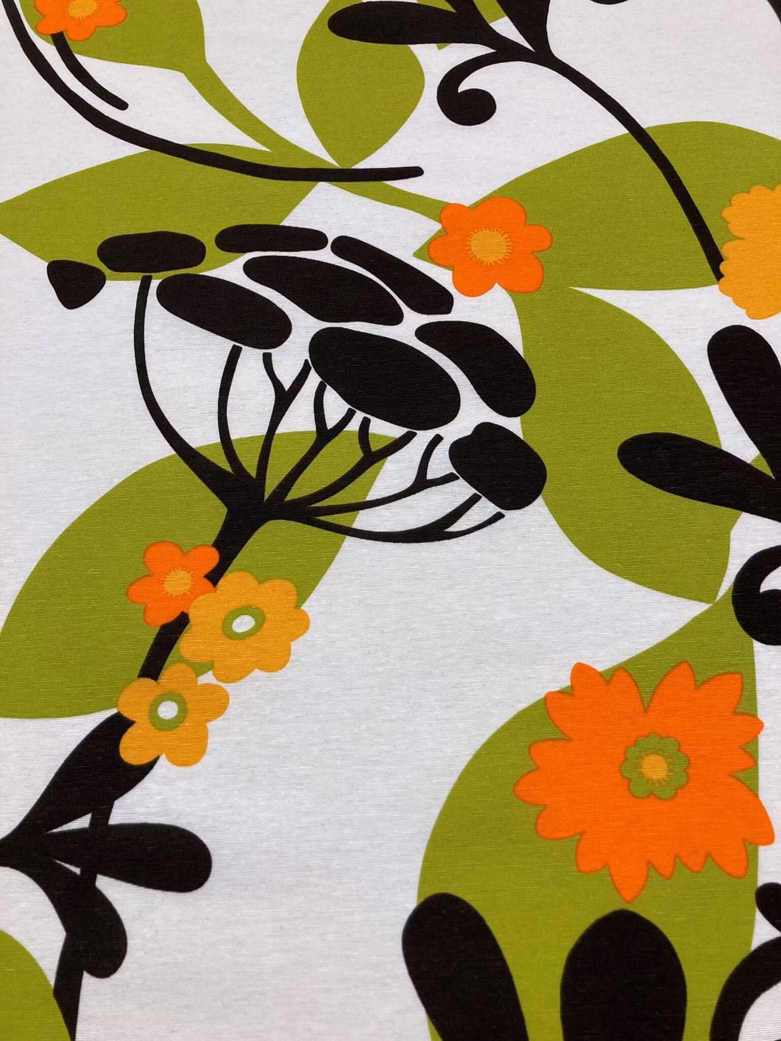 Närbild av Retroblom metervara med grafiska retroblommor och 70-talskänsla