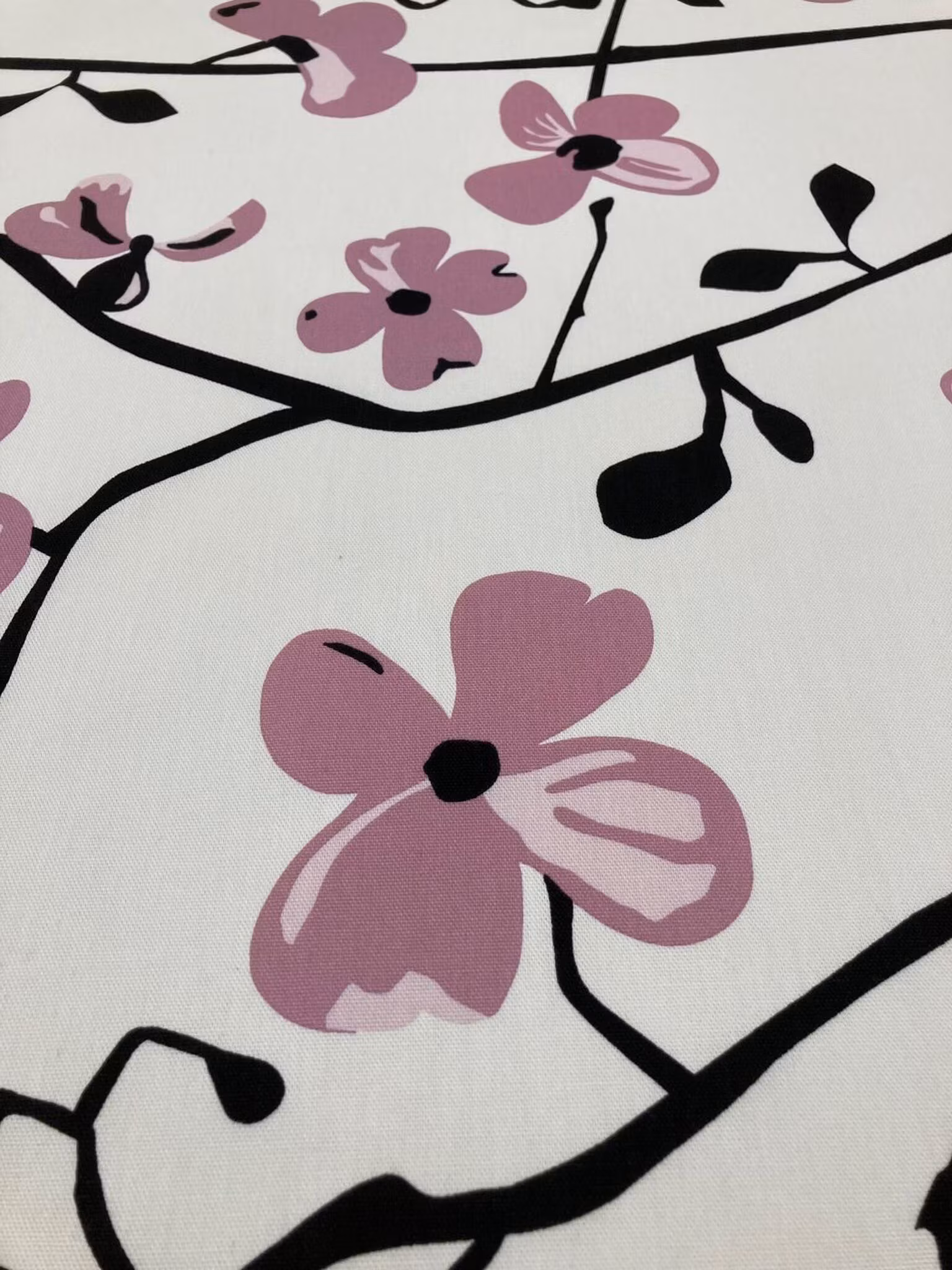 Närbild av Yoko rosa metervara med rosa blommor och dekorativa grenar