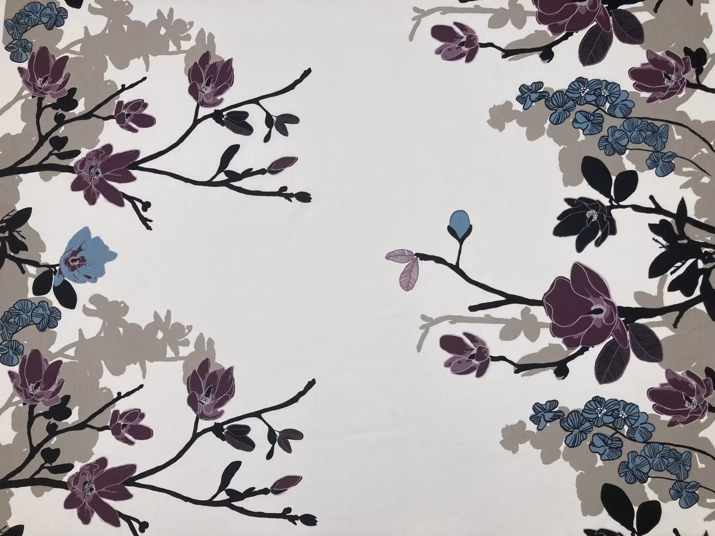 Grandiflora multi bomullstyg med magnoliakvistar i plommonlila, blå och svarta toner mot ljus botten.