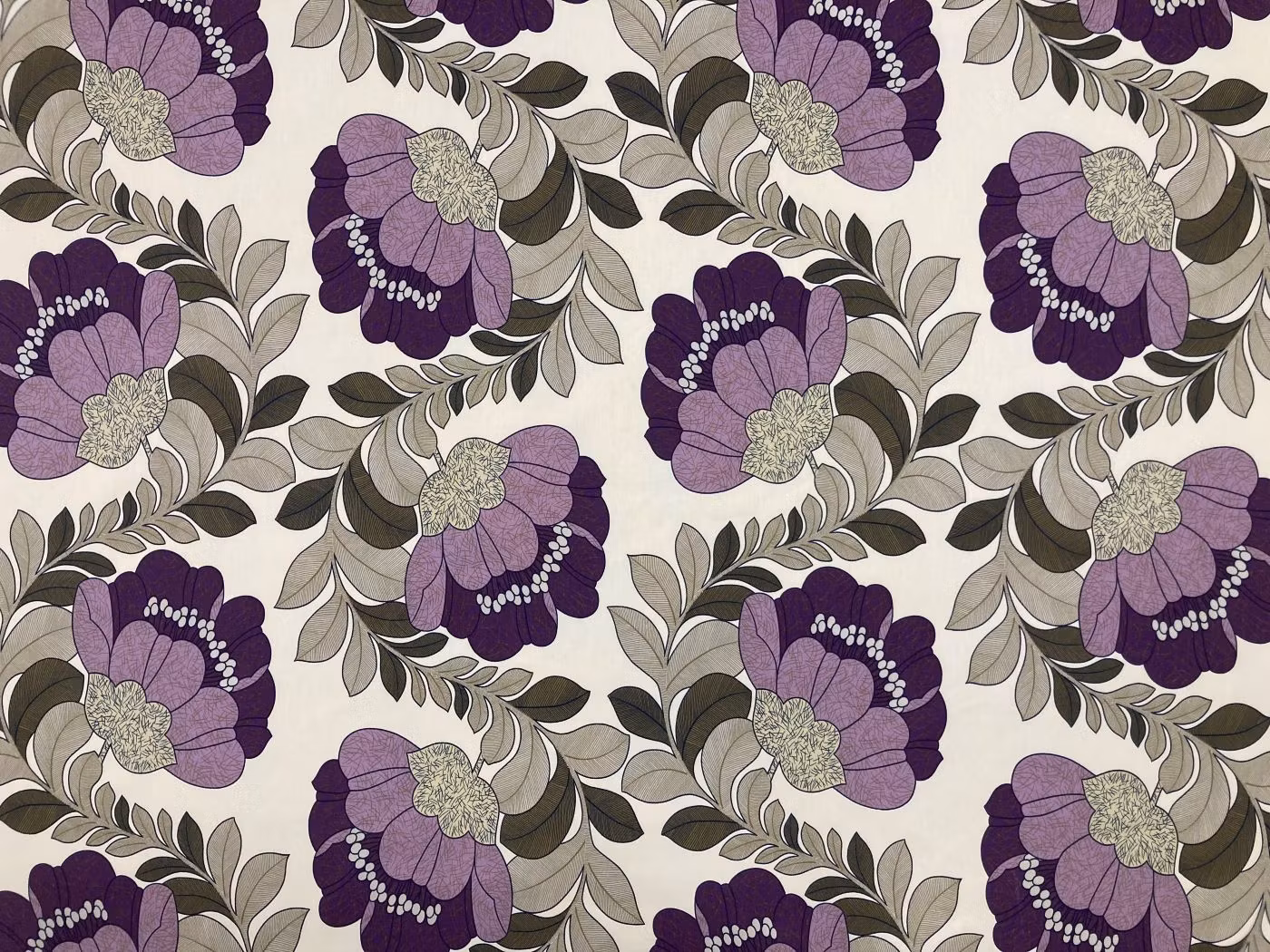 Retro lila kraftigt tyg med retroinspirerat blommönster i lila, syren och grågröna toner.