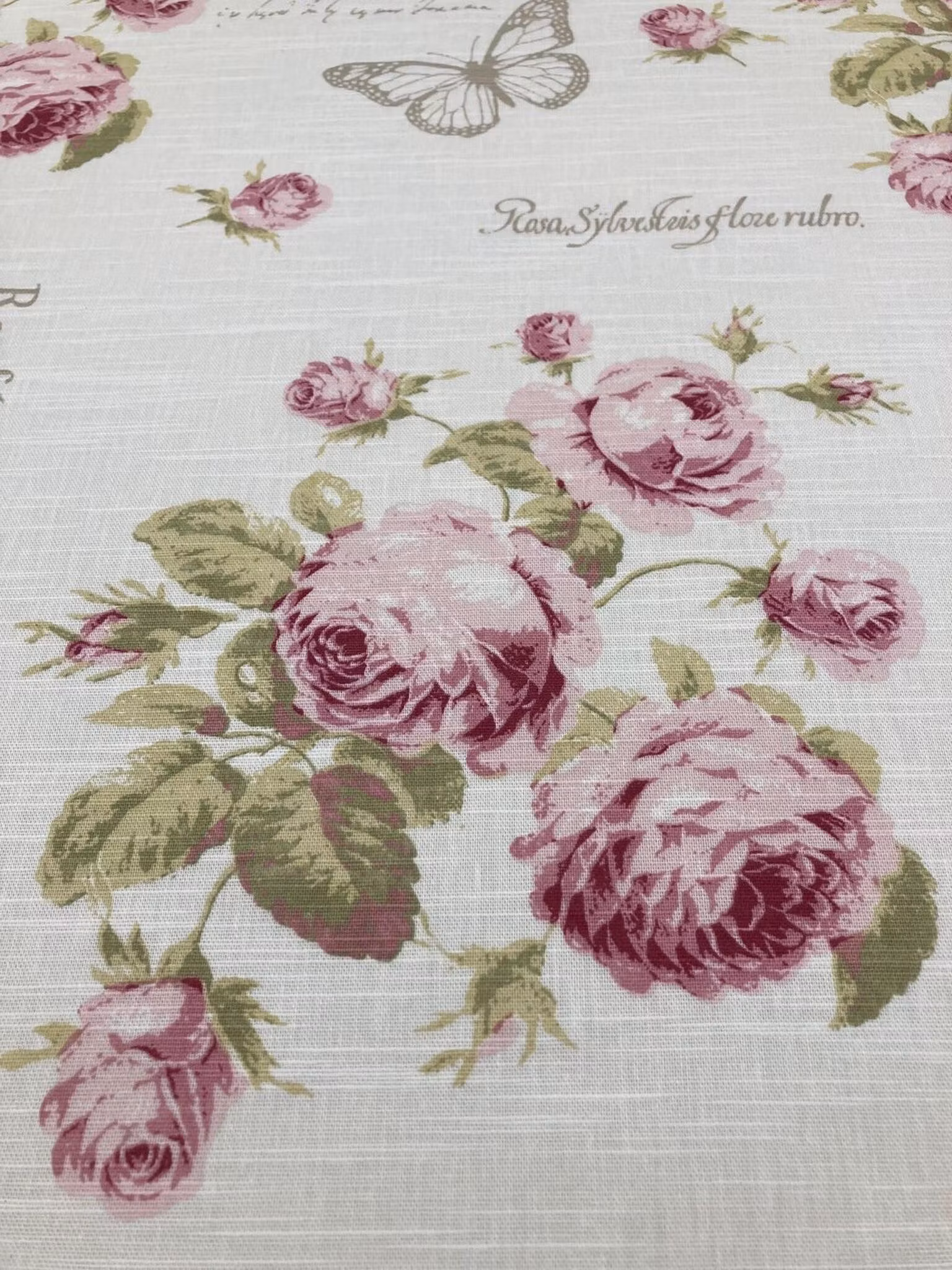 Närbild av Scarlet som visar de rosa rosorna och bomullstygets struktur.