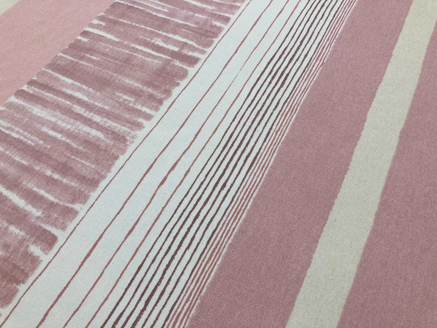 Närbild av Summer som visar det randiga mönstret i rosa toner och bomullstygets struktur.