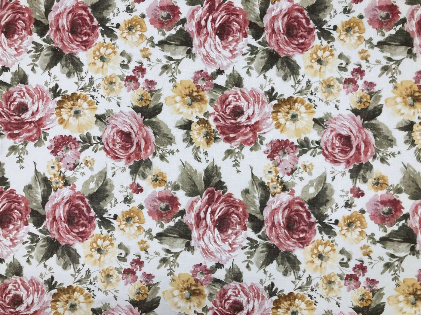 Blommigt tyg Dibujo med stora rosa och vinröda rosor, små blommor och gröna blad på vit botten.