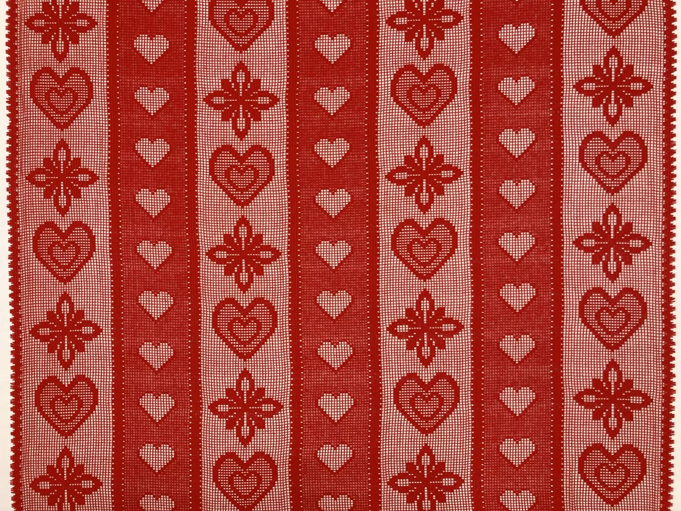 Röd julspets med hjärtmönster, genombruten spetsväv i metervara.