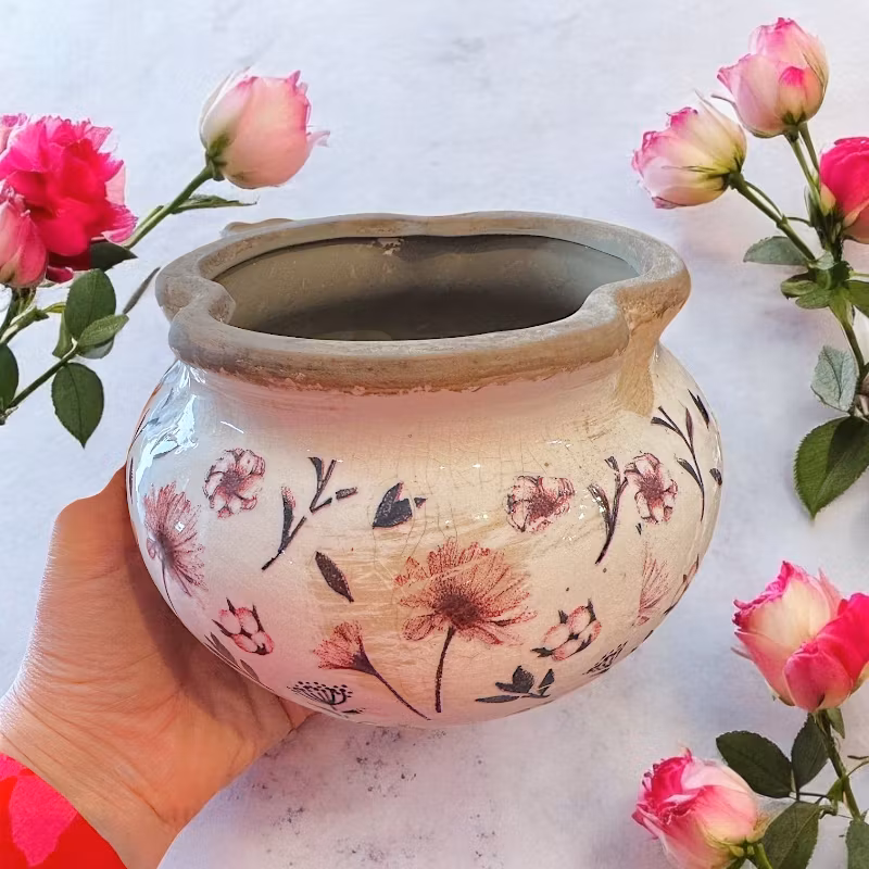 Rund kruka med ljusrosa blommor