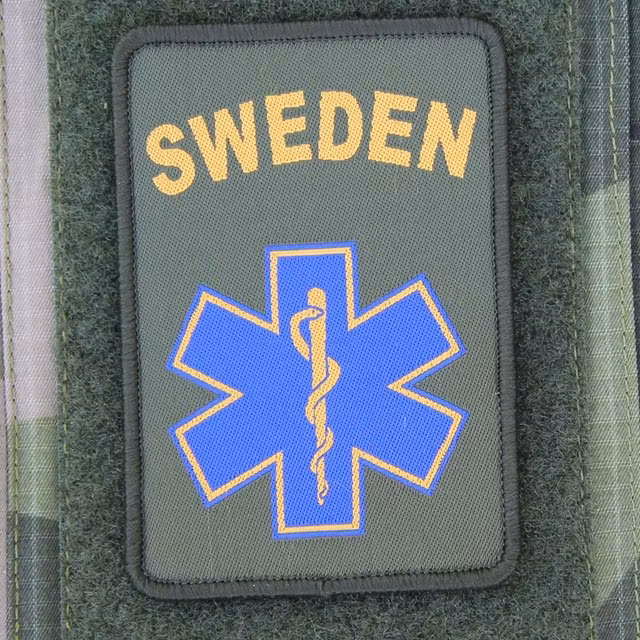 SWE MEDIC Star Hook Patch mounted on arm of a M90 camouflage jacket.
