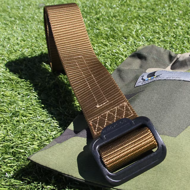 Grassy background and the sun is out, featuring a Expedition Belt Coyote on a M90 bag.