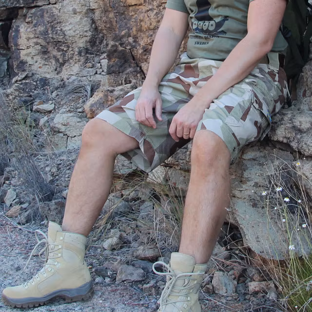 Camp Shorts M90K Desert on sitting model in desert landskape.