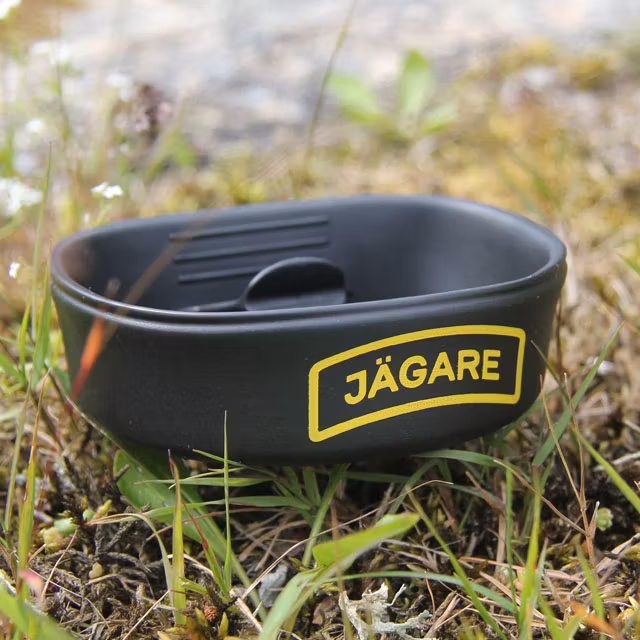A folded Folding Cup JÄGARE Black/Yellow/Black on summer scenery ground.