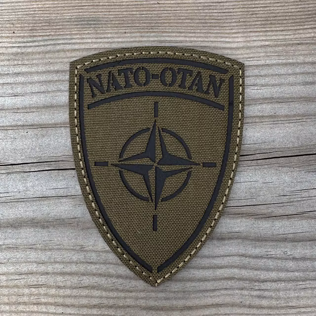 IR-NATO Shield Reflective Green Hook Patch displayed on a wooden surface