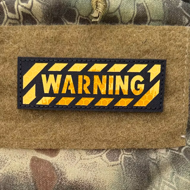 IR Warning Cut-Out Patch mounted on a camouflage backpack, close-up