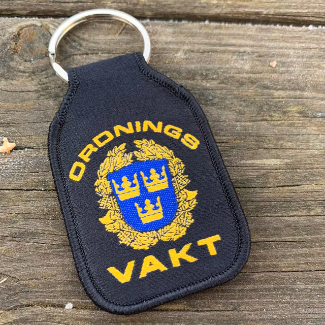 Ordningsvakt Nyckelring liggandes på planka