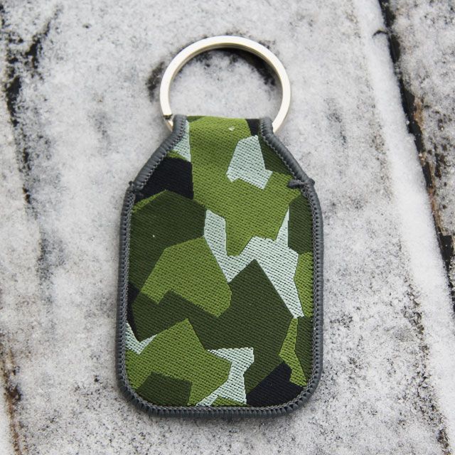 A M90 Keyring TUG with its silver ring for the keys on frosty background.