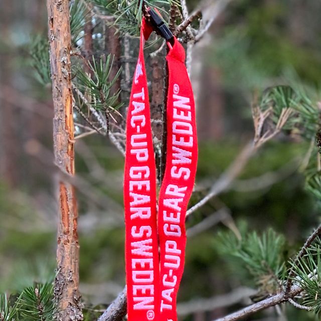 Lanyard Red/White hanging on a branch