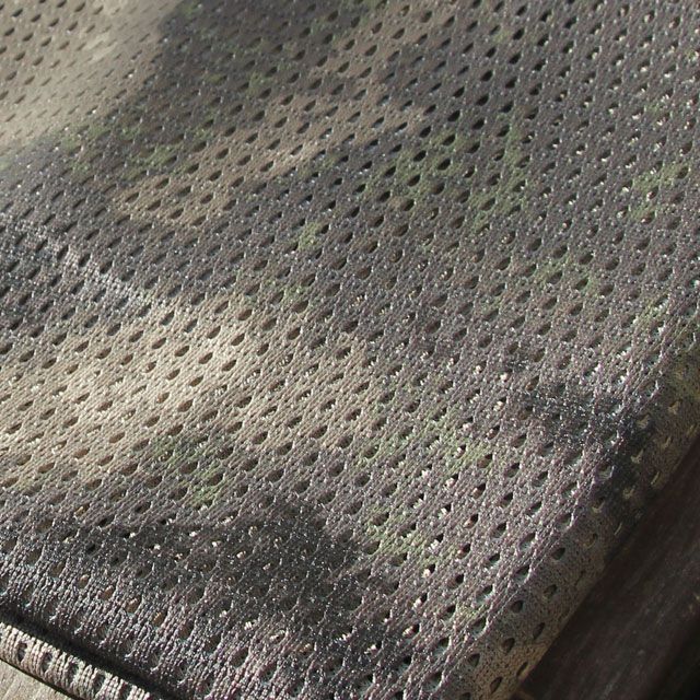 Small holes perforate the camouflage fabric on a Sniper Scarf Archipelago.