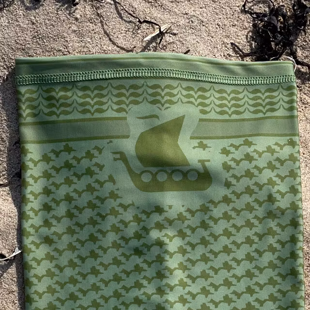 A closeup on a Neck Tube Shemagh Lime Green from TAC-UP GEAR lying flat on sand