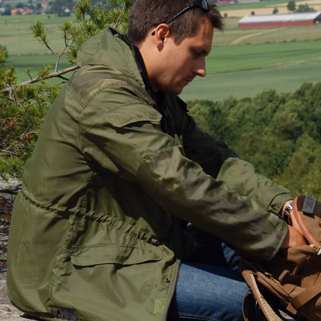 On the look out hill wearing a Nomad Jacket Green.