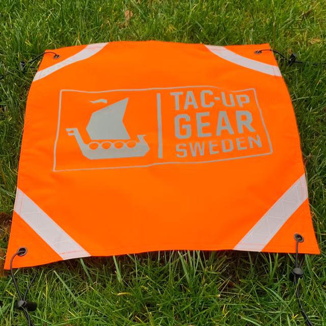 Orange Ruck Signal Panel Marker outdoors on grassy background.