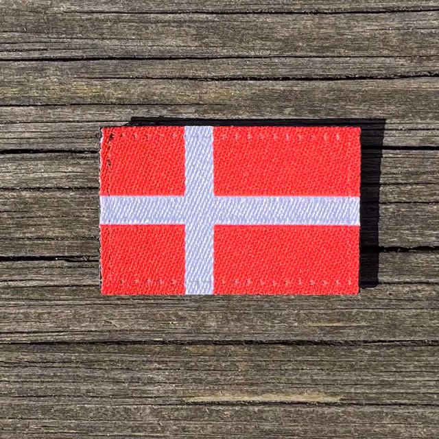 Denmark Flag Hook Patch Small from TAC-UP GEAR lying flat on wood