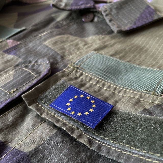 A Blue and yellow EU Flag Hook Patch Small from TAC-UP GEAR on a M90 shirt breast