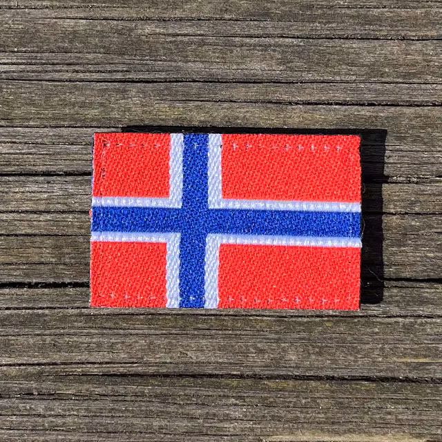 Norway Flag Hook Patch Small from TAC-UP GEAR lying flat on wooded plank