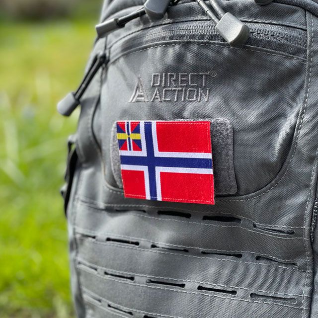 Ett tygmärke med kardborre: Norges handelsflagga 1844–1898/99 som ses från sidan på en grå ryggsäck