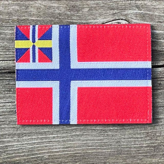 Norges handelsflagga 1844–1898/99 som ett tygmärke med kardborre på baksidan