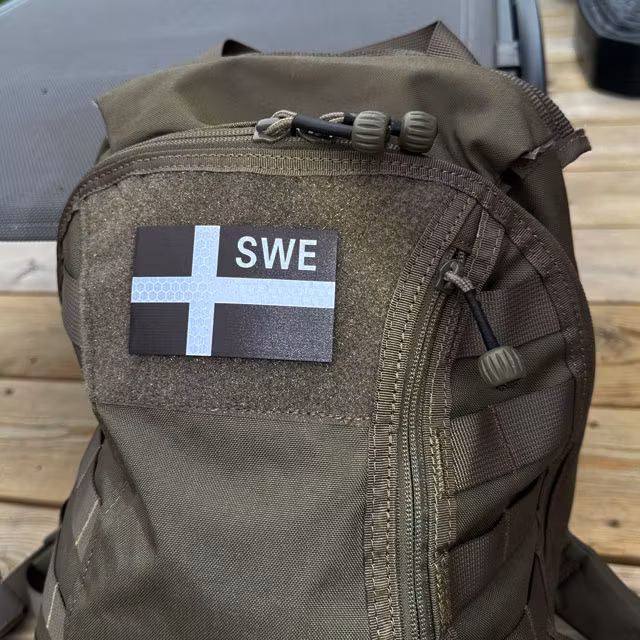 IR - SWE Black and Grey Flag Hook Patch mounted on a rucksack