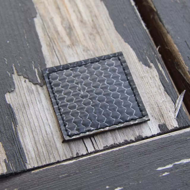 A IR Tactical Glint Square - 4 cm on a woody background.