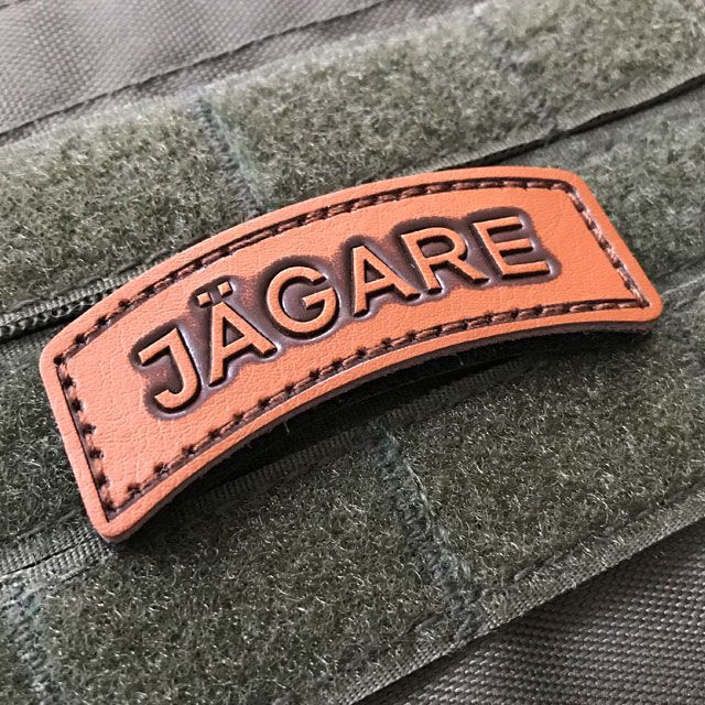 A JÄGARE Leather Hook Patch on green velcro background.