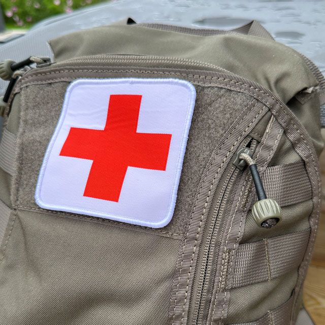 a Medic Red Cross Hook Patch M17 mounted on a rucksack