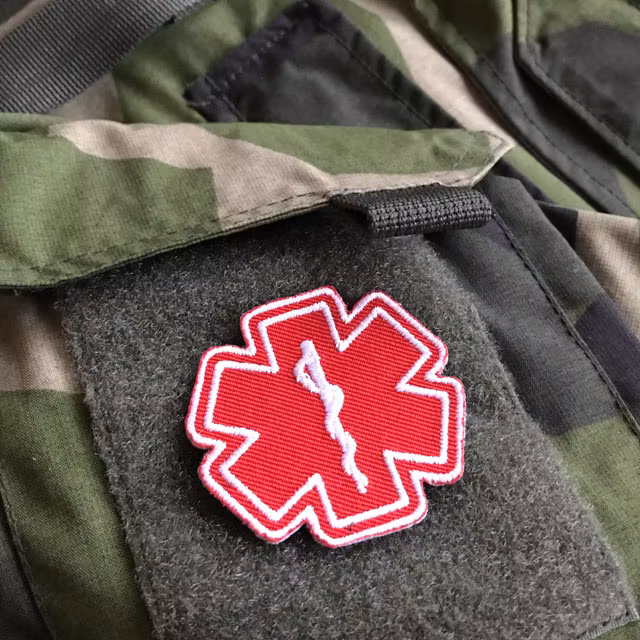 M90 camouflage jacket and a MEDIC Star of Life Red White Hook Patch.