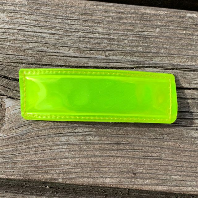 A Reflective Hook Patch Yellow on wooden board