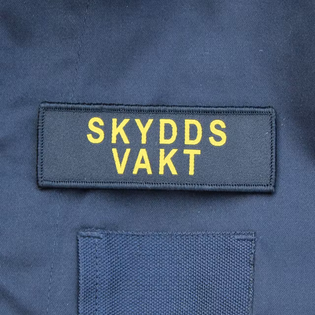 Skyddsvakt Avlång Kardborremärke på Marinens blåa uniformsjacka.