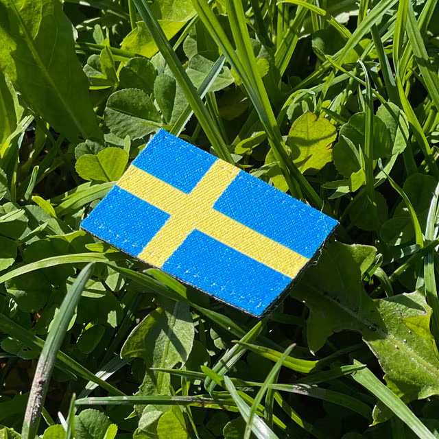 A Sweden Flag Hook Patch Arm with grass background