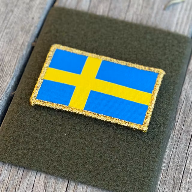 A Sweden Flag Gold from TAC-UP GEAR on green loop fabric