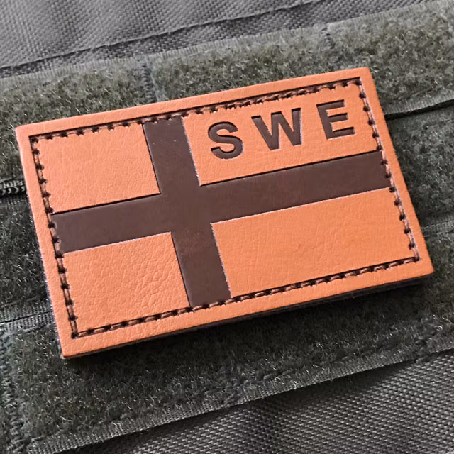 A Sweden Flag Leather Patch mounted on a ranger green plate carrier.