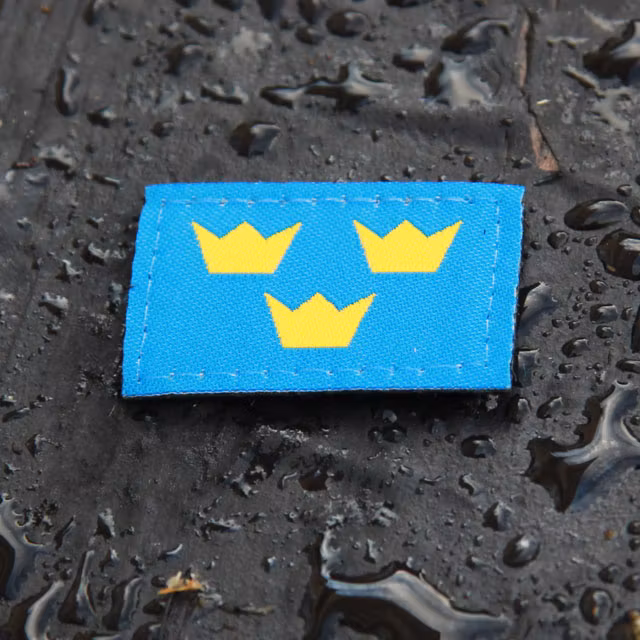 Three Crowns Morale Patch on wet background.