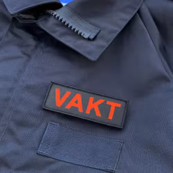 VAKT Röd text Kardborremärke