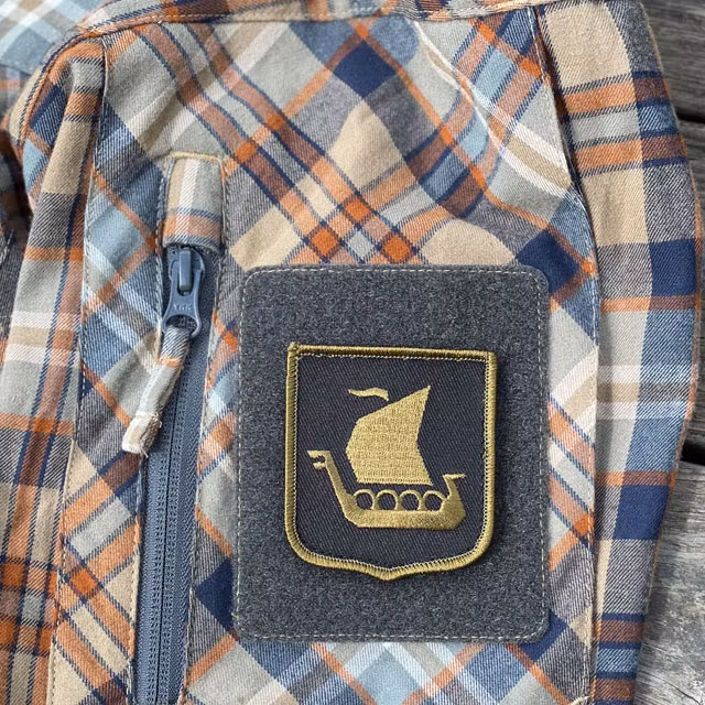 Viking Ship Shield Large Olive and Black Hook Patch mounted on an arm on a shirt