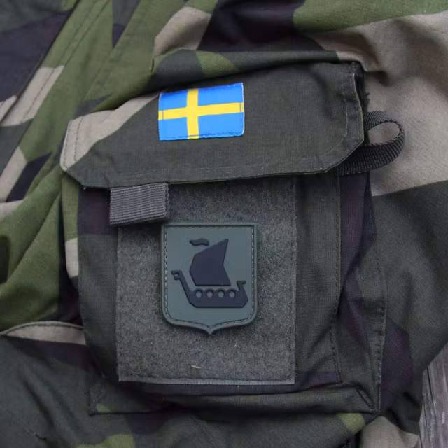 Ett Vikingship Shield Hook PVC Green/Black Patch märke monterat på en NCWR Jacka M90.