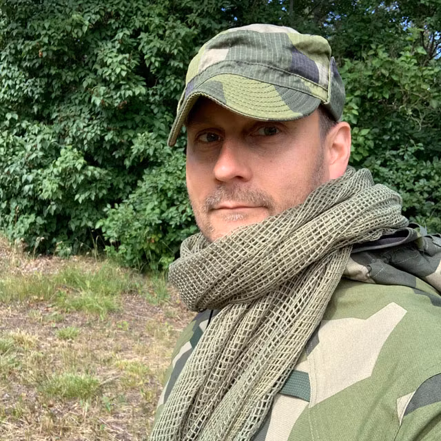 A Scrim Net Scarf Green worn around the neck